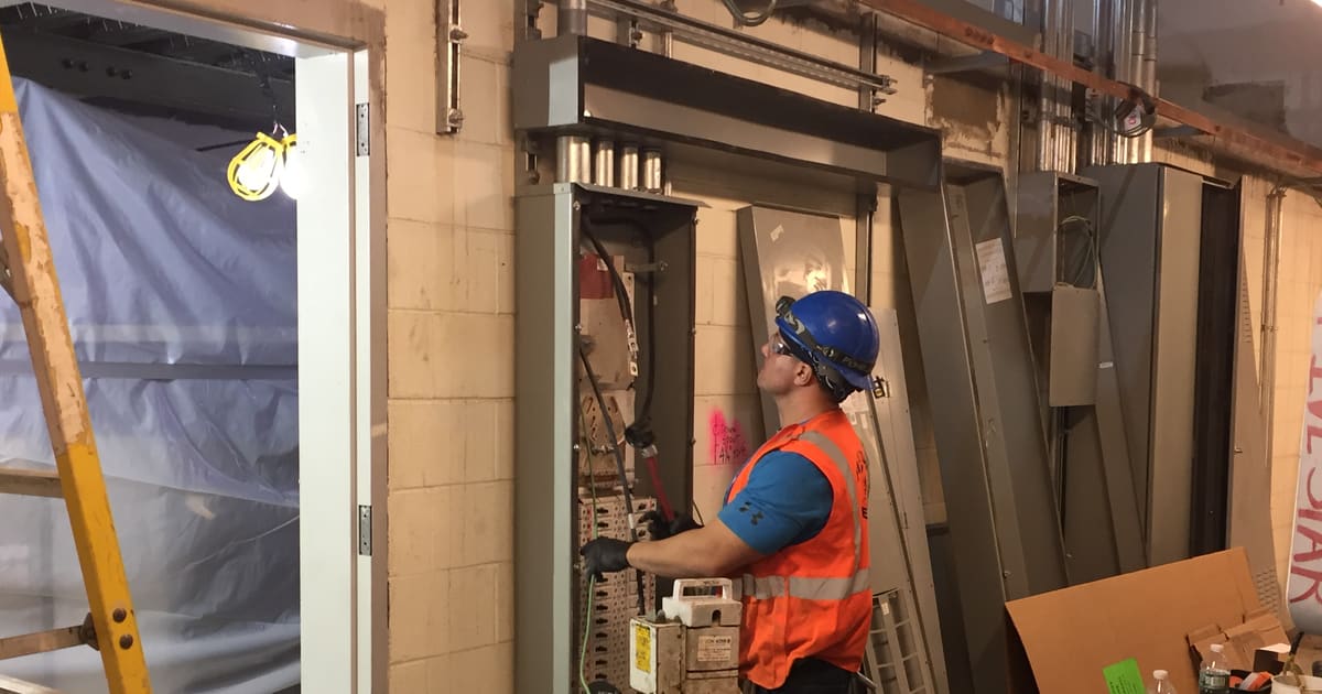 Eletricista instalando fiação em quadro elétrico residencial